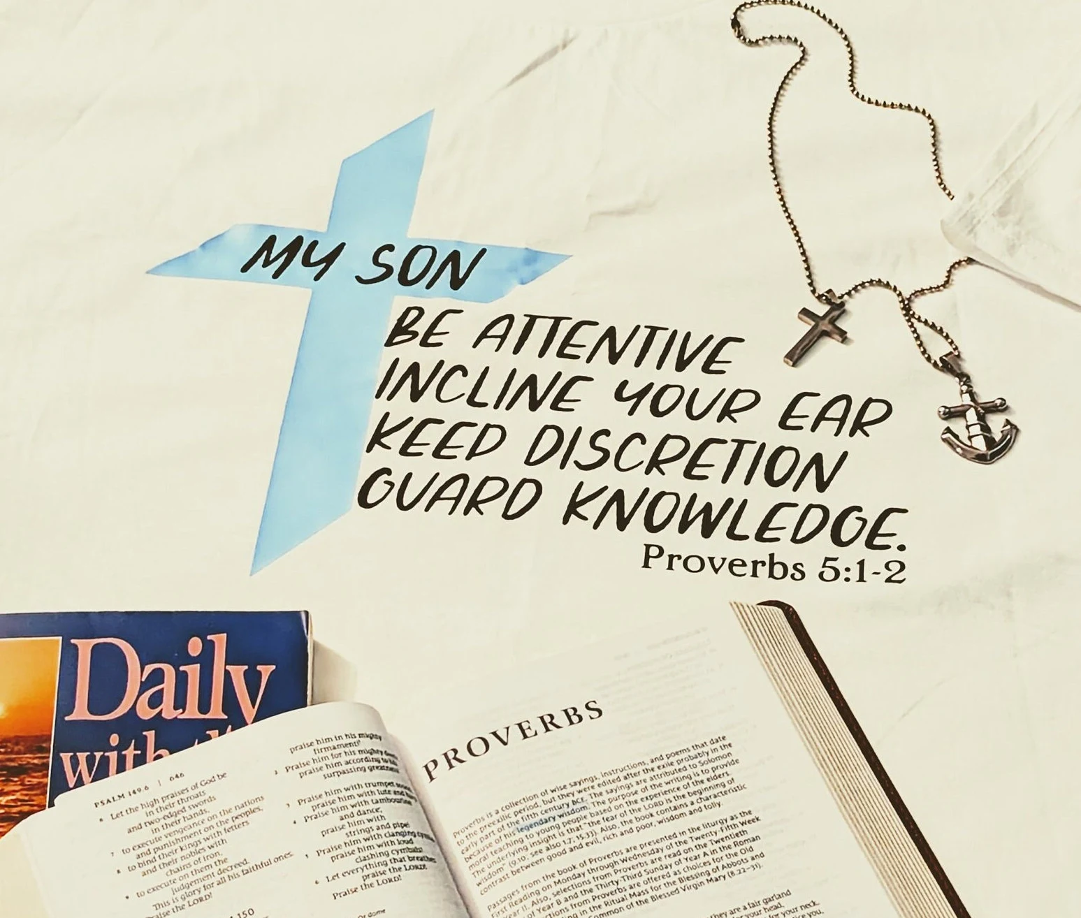 White shirt with Proverbs 5:1-2 design and blue cross